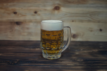 mug of light beer on a wooden background