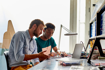 Teacher Discussing With Young Student Over Laptop