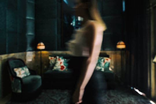 Motion Blur of Woman Walking Through Hotel Dark Green Hotel Lobb