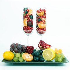 two glasses filled with fruit on a light background