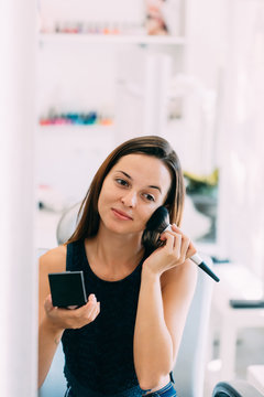 Brunette woman putting makeup on at a spa center