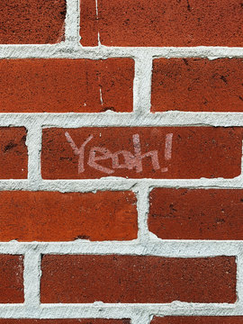 Yeah!"" written on a brick wall