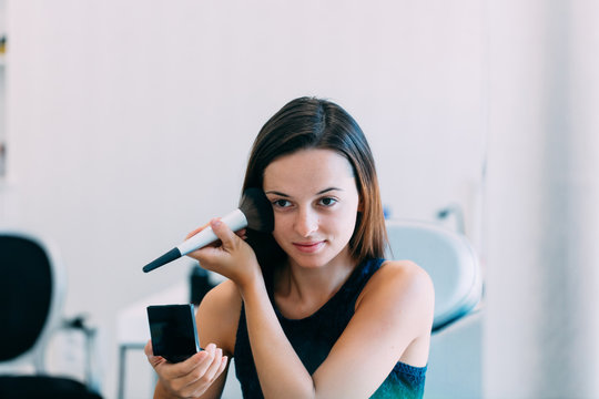 Brunette woman putting makeup on at a spa center