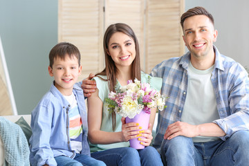 Happy family with bouquet of beautiful flowers at home