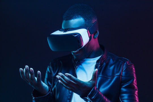 Fototapeta African man pictured in darkness feeling positive and enjoying opportunities of virtual reality