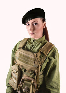 Young beautiful soldier woman in miliary beret and protective armor tactical vest, isolated photo.