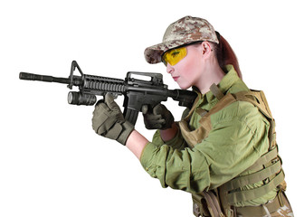 Young soldier woman aiming at the enemy with automatic rifle.