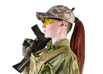 Portrait of young and beautiful military soldier woman with red hair holding an automatic rifle M16, isolated photo.