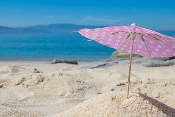 Fototapeta na wymiar parasol in the sand of the beach, summer and holidays
