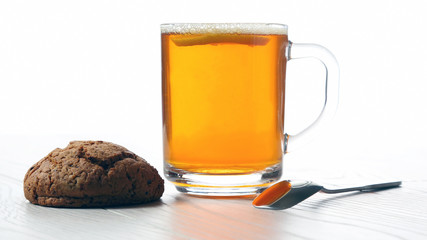 cup of tea with lemon and cookies on a wooden table