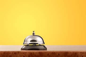 Vintage hotel reception service desk bell on blue wall background