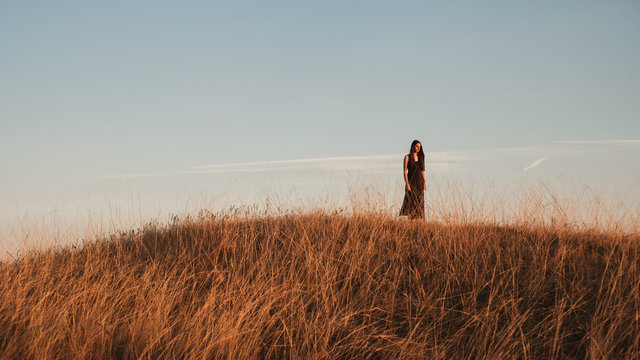 Wide Shot Of A Woman In The Field Against The Blue Sky