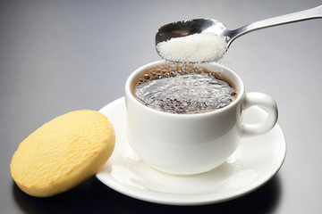 white cup with black coffee and spoon with sugar