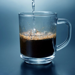 black coffee is poured in a transparent mug. hot drink.