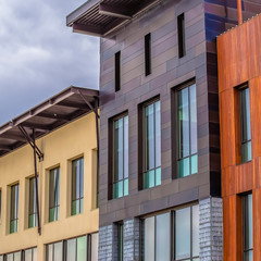 Square frame Building exterior with a flat roof against sky covered with puffy gray clouds