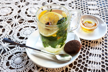 Cup of tea with lemon, mint, ginger and dessert