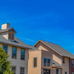 Square Exterior view of houses with vast blue sky background on a sunny day