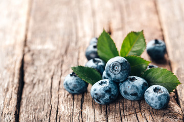 Freshly picked blueberries on wooden background. Healthy eating and nutrition.