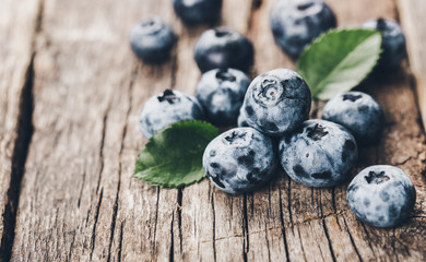Freshly picked blueberries on wooden background. Healthy eating and nutrition.