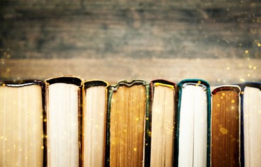 Ancient books in a row on wooden background