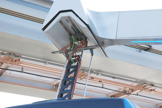 Charger for electric buses in process of charging battery on the roof of the bus, close-up
