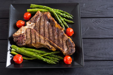 Grilled T-bone steak with asparagus and cherry tomatoes