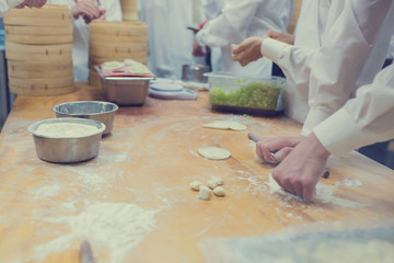 Dim Sum chefs working wrapping dumplings at famous restaurant in Taiwan.