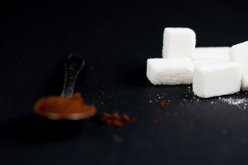 Coffee spoon and sugar cubes isolated on a black background