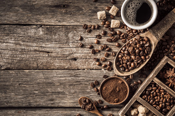Coffee cup with coffee beans on wood background.