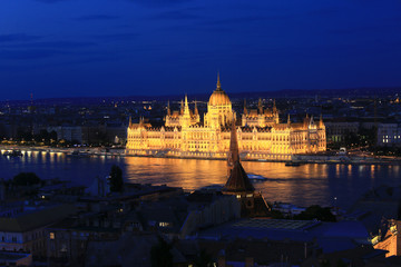 Fototapeta na wymiar Beautiful night view of the Hungarian Parliament building and the Danube river with lights in the water in Budapest, Hungary