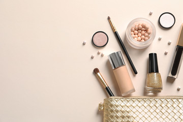 Cosmetic bag and different luxury makeup products on color background, flat lay. Space for text