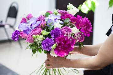 Female florist explain to students how to create bouquet at workplace. Floristics workshop.  Making beautiful flower bouquets and floral decorations.