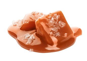 Caramel candies under tasty sauce with salt isolated on white