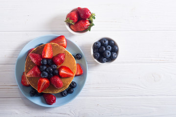 Tasty pancakes with blueberry and strawberry