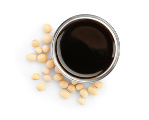 Obraz na płótnie Canvas Bowl of tasty soy sauce and beans isolated on white, top view