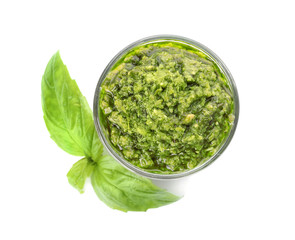 Bowl of tasty pesto sauce with basil leaves isolated on white, top view