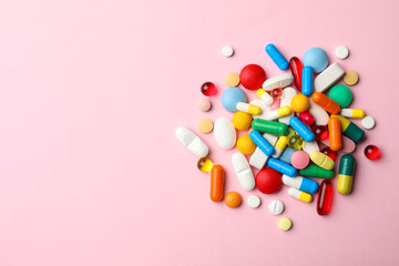 Pile of different pills on color background, top view. Space for text
