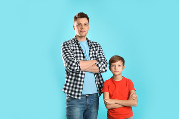 Obraz premium Portrait of dad and his son on color background