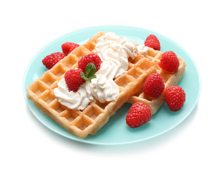 Plate with yummy waffles, whipped cream and raspberries on white background