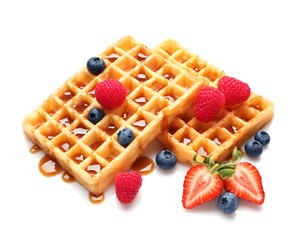 Yummy waffles with berries and caramel syrup on white background