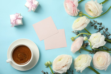 Flat lay composition with spring ranunculus flowers and cards on color background. Space for text