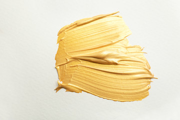 Golden paint brush strokes on white background