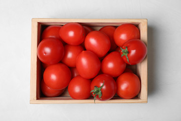 Wooden crate full of fresh delicious tomatoes on table, top view