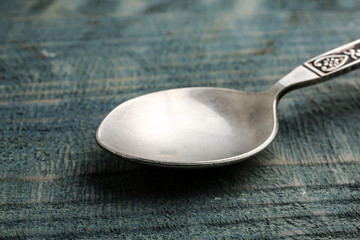 Clean vintage tea spoon on wooden background, closeup
