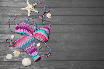 Flat lay composition with stylish bikini on wooden background. Space for text