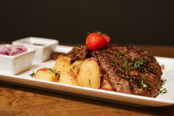 Steak with vegetables, potato and sauce  in the restaurant