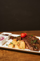 Steak with vegetables, potato and sauce  in the restaurant