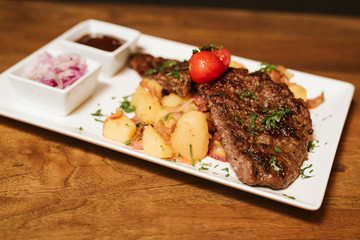 Steak with vegetables, potato and sauce  in the restaurant