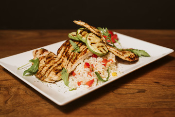 Grilled chicken with rice and vegetables by the glass of juice