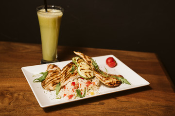 Grilled chicken with rice and vegetables by the glass of juice